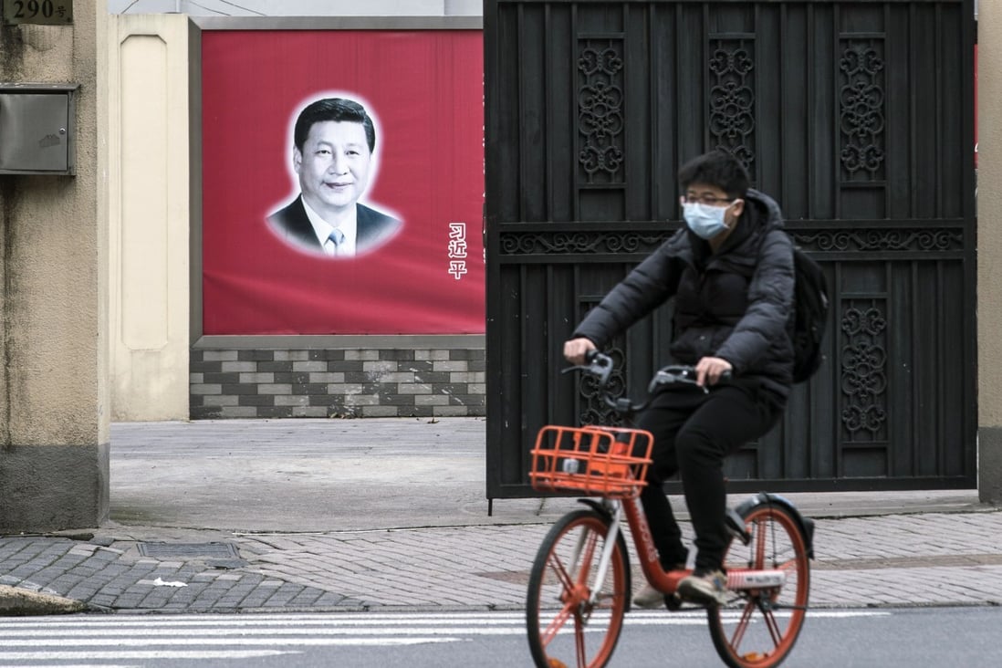 A cyclist in Shanghai rides past a banner featuring an image of Chinese President Xi Jinping on Monday. Photo: Qilai Shen/Bloomberg