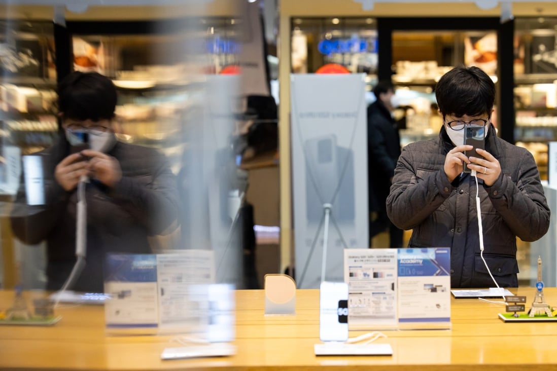 A customer wearing a protective mask looks at Samsung Electronics’ Galaxy S20 smartphone at the company's D'light flagship store in Seoul, South Korea, on March 6. Photo: Bloomberg