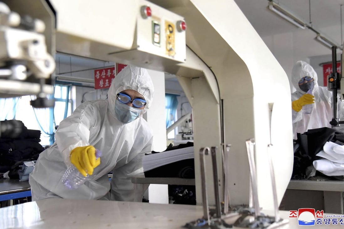 Workers wearing protective suits spray disinfectant as a precaution against the new coronavirus at a factory in Pyongyang. Photo: Korean Central News Agency/ AP