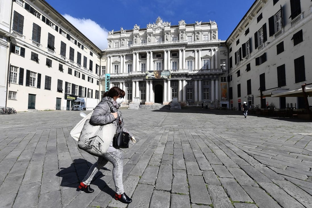 A woman wearing a face mask walks by the almost deserted Ducal Palace square in Genoa, Italy, on Wednesday. Photo: EPA-EFE