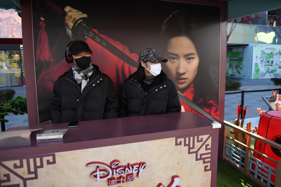 Workers man a promotional stand for the Disney move Mulan in an almost empty shopping mall in Beijing. The film’s global launch has been postponed amid the coronavirus outbreak. Some Hong Kong film fans are unlikely to welcome its eventual release. Photo: AFP