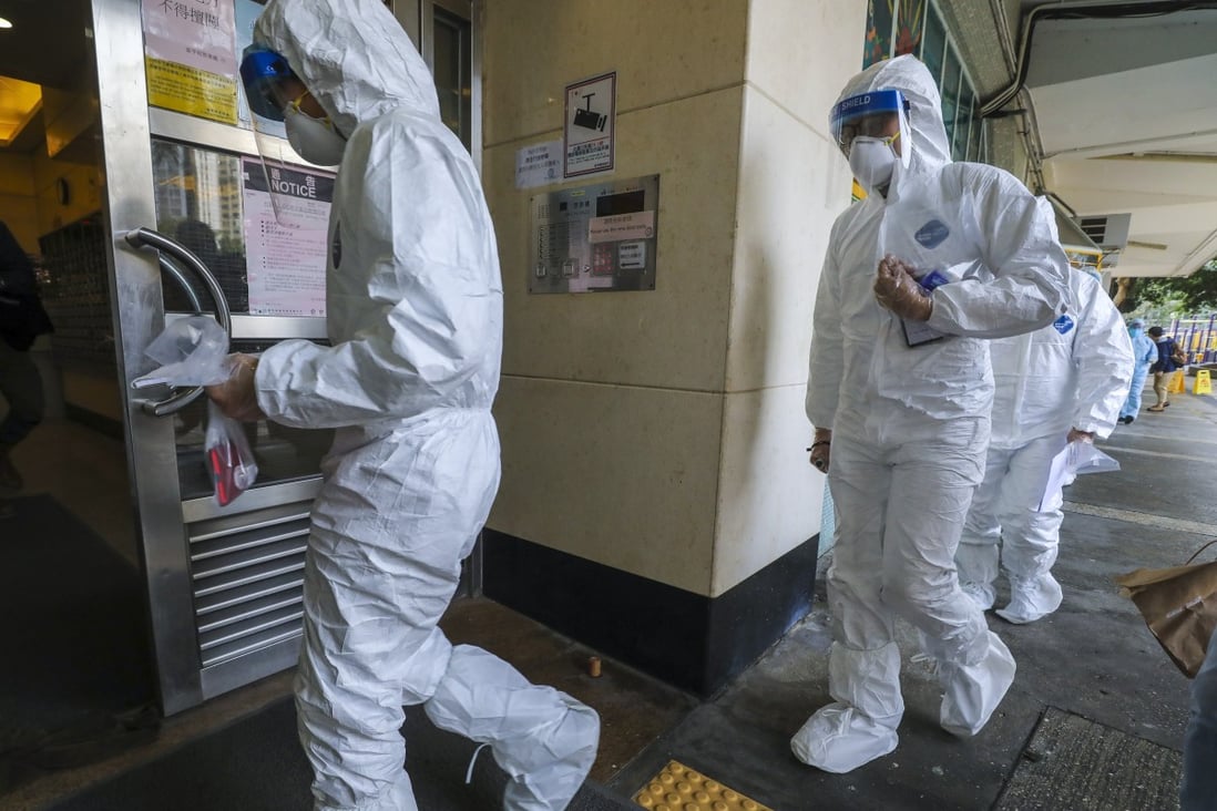 Paramedics in full protective gear enter Heng Tei House on Sunday Photo: Dickson Lee