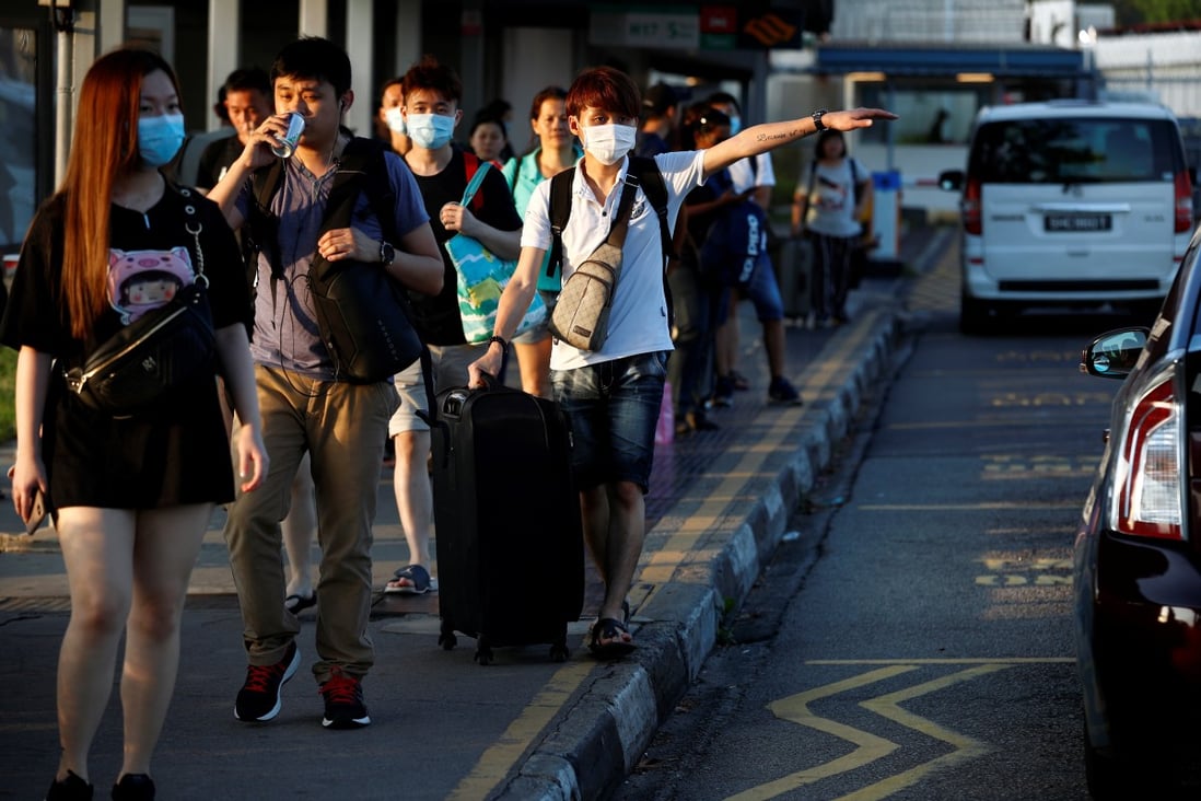 Commuters from Johor, Malaysia, head to Singapore on March 17, hours before Malaysia imposes a lockdown on travel due to the coronavirus outbreak. Photo: Reuters