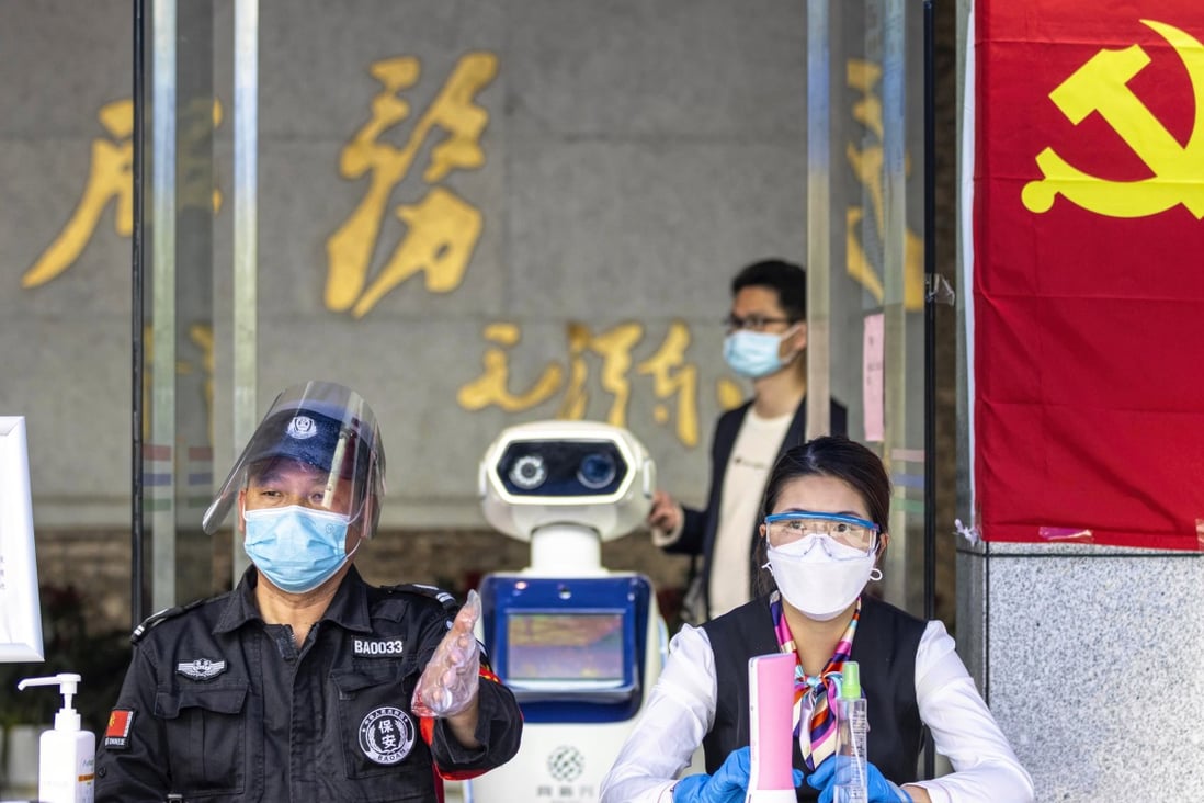 A robot checks visitors’ body temperatures at the entrance of a government building in Guangzhou. Photo: EPA-EFE