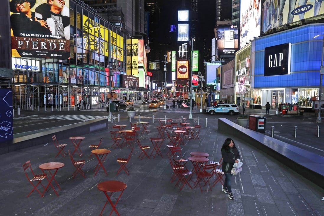 A woman walks through a lightly trafficked Times Square in New York, Monday, March 16, 2020. Bars and restaurants will become takeaway-only and businesses from cinemas and casinos to gyms and beyond will be closed. Photo: AP