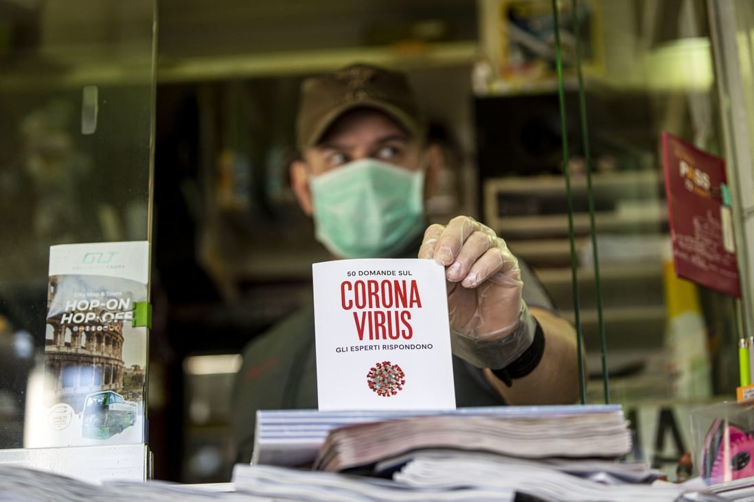 A shop vendor shows a publication about the virus during the coronavirus emergency, Rome, Italy, 18 March 2020. Photo: EPA-EFE