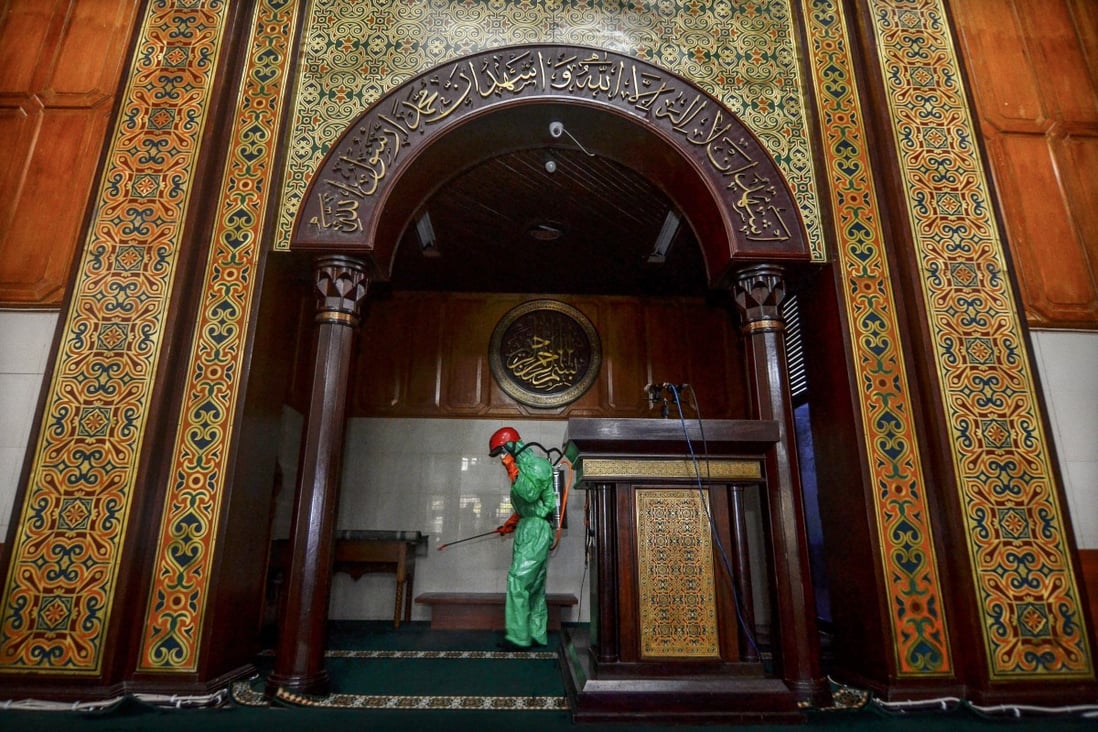 A worker sprays disinfectant in mosque amid the coronavirus outbreak in Indonesia. Thousands of Muslim pilgrims have gathered in Gowa, near the provincial city of Makassar. Photo: Reuters
