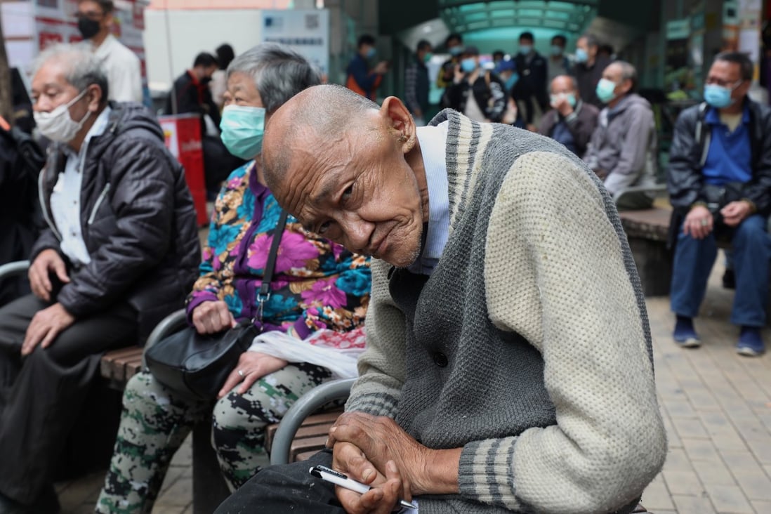An elderly man sits on a bench in Sham Shui Po and waits for his turn as a charity gives out bleach on March 5. Photo: Xiaomei Chen