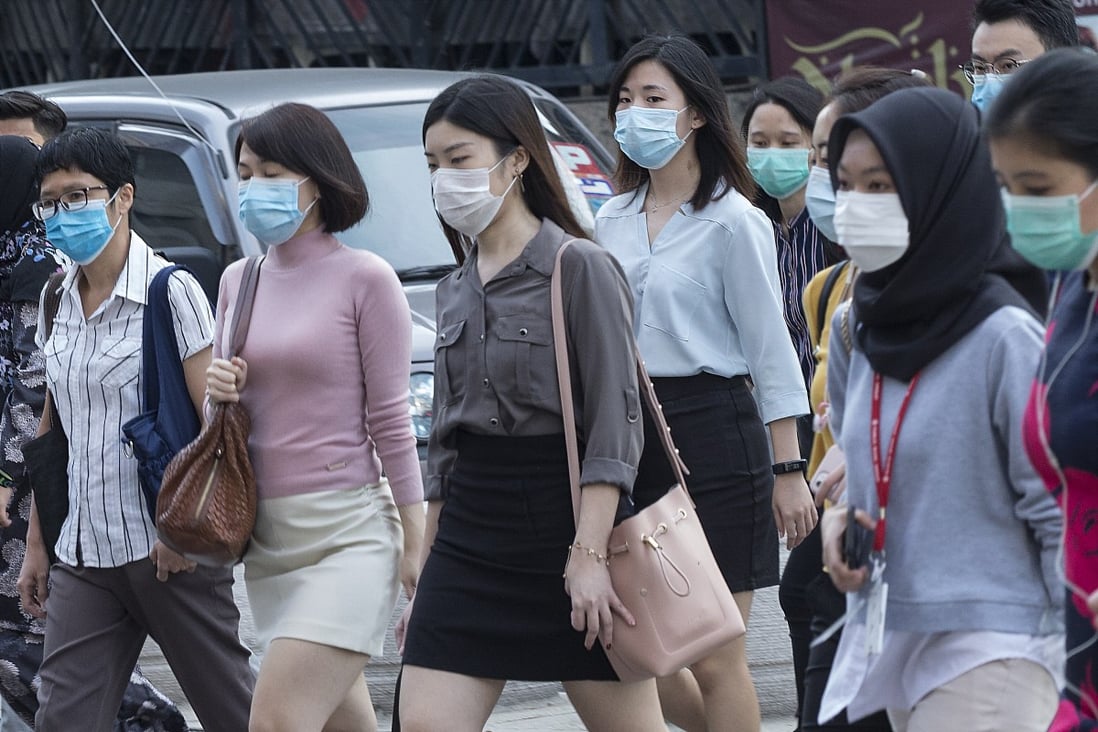 Workers walk to their offices while wearing face masks during a coronavirus lockdown day in Kuala Lumpur on Wednesday. Photo: EPA