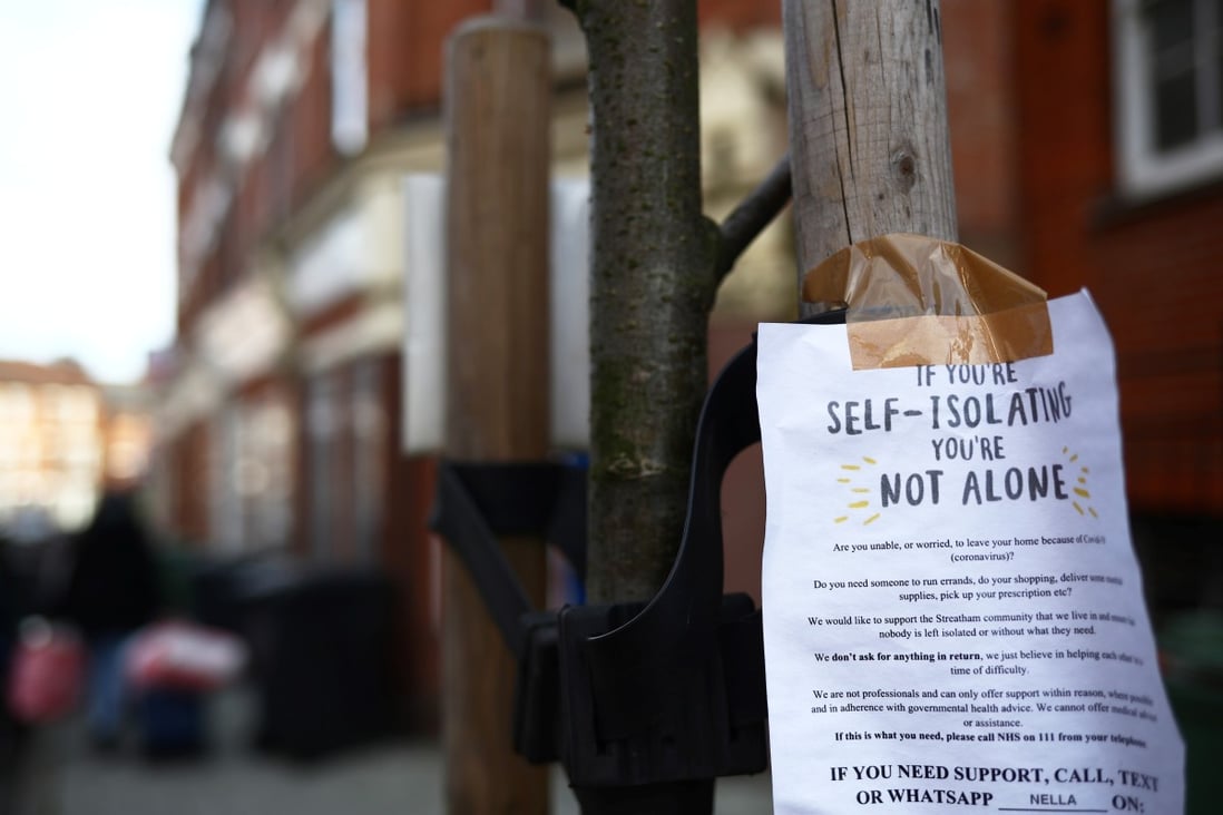 A sign is seen down a London street regarding self isolation. Photo: Reuters