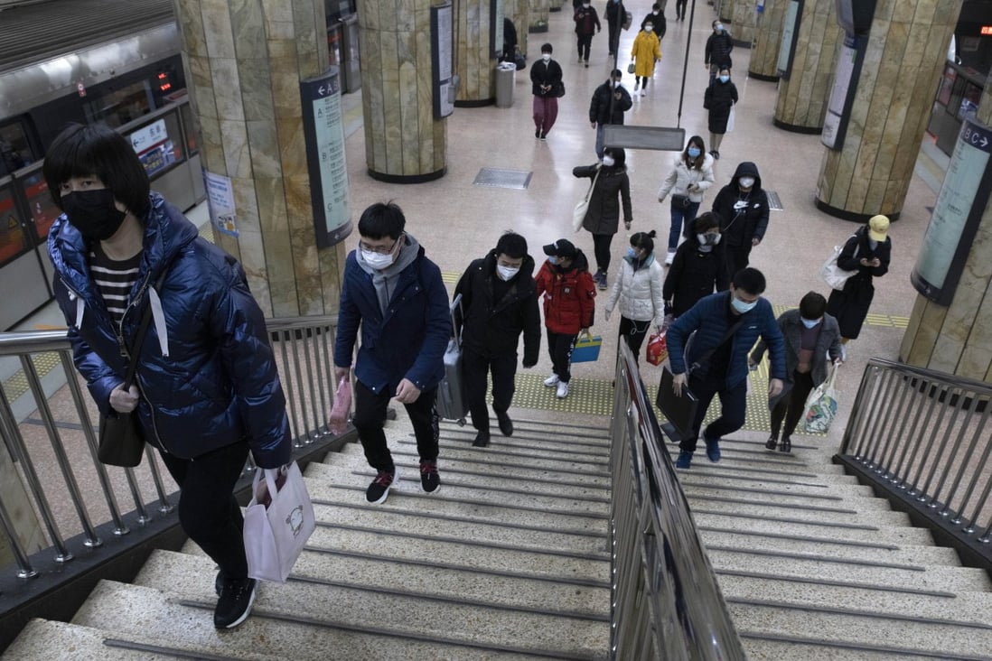 Commuters in Beijing head to work – health officials are watching as China reports a fall in the number of new coronavirus cases. Photo: AP