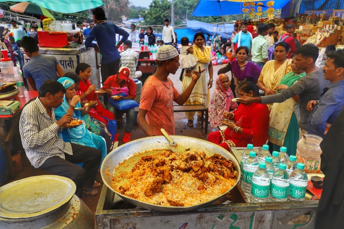 A Biryani vendor speaks with a customer at Jama Masjid in Old Delhi, India. The story of the classic South Asian dish is a long and colourful one. Photo: Getty Images