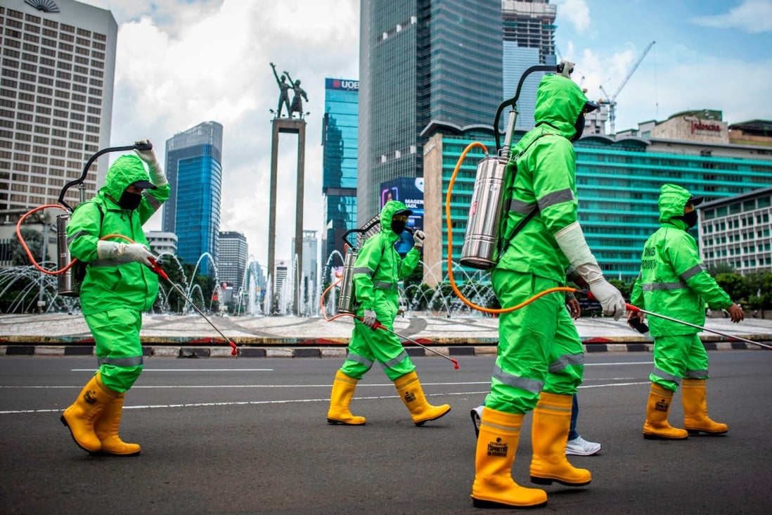 Workers spray disinfectant in Jakarta, Indonesia, on March 22, 2020. Photo: Antara Foto via Reuters