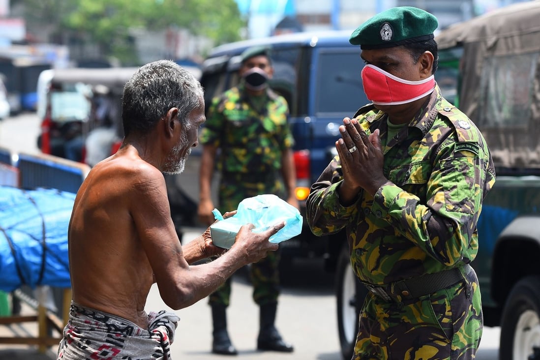 Police commandos in Sri Lanka hand out food to homeless people during a nationwide curfew against the spread of coronavirus. Photo: AFP