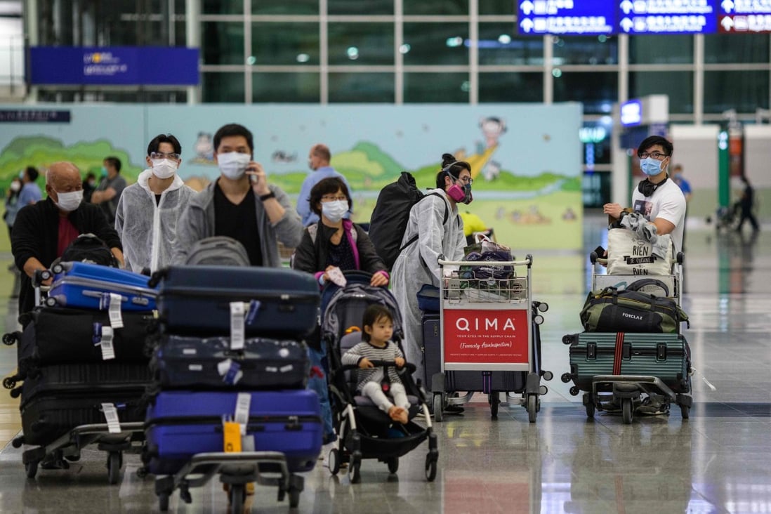 Newly arrived passengers wear protective gear as a precautionary measure against the Covid-19 at the arrivals hall of Hong Kong’s international airport on Tuesday. Photo: AFP