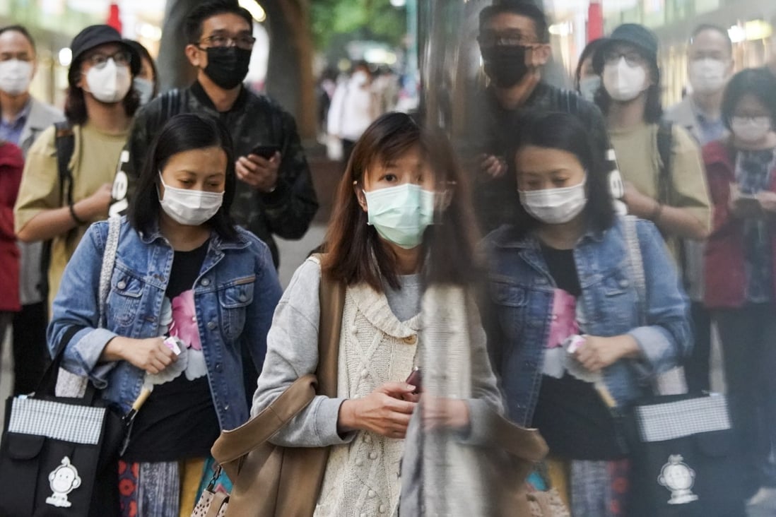 Pedestrians wearing face masks walk a street in the Tsim Sha Tsui district, following the outbreak of the new coronavirus in Hong Kong. Photo: Felix Wong