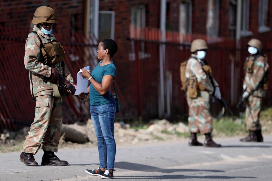 A South African soldier checks the documents of a resident of Alexandra township, as the military enforces a three-week nationwide lockdown in the country to stem the spread of the coronavirus pandemic. Photo: Reuters