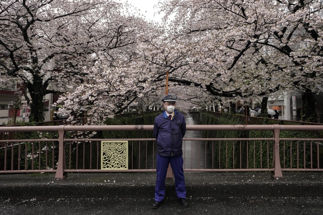 A security guard stands on a bridge on the River Meguro to warn visitors to avoid crowds in Tokyo, amid the coronavirus outbreak. Photo: EPA-EFE