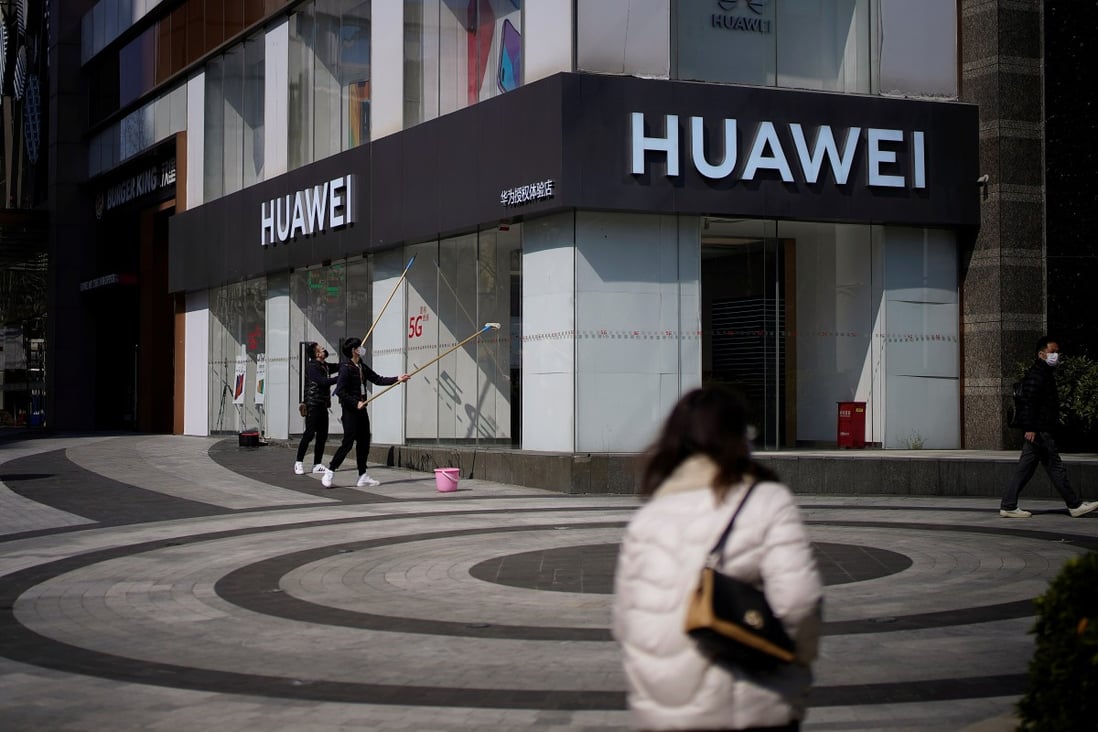 People wearing face masks are seen at a Huawei shop on a street in Shanghai as China is hit by an outbreak of the novel coronavirus. Photo: Reuteres/Aly Song