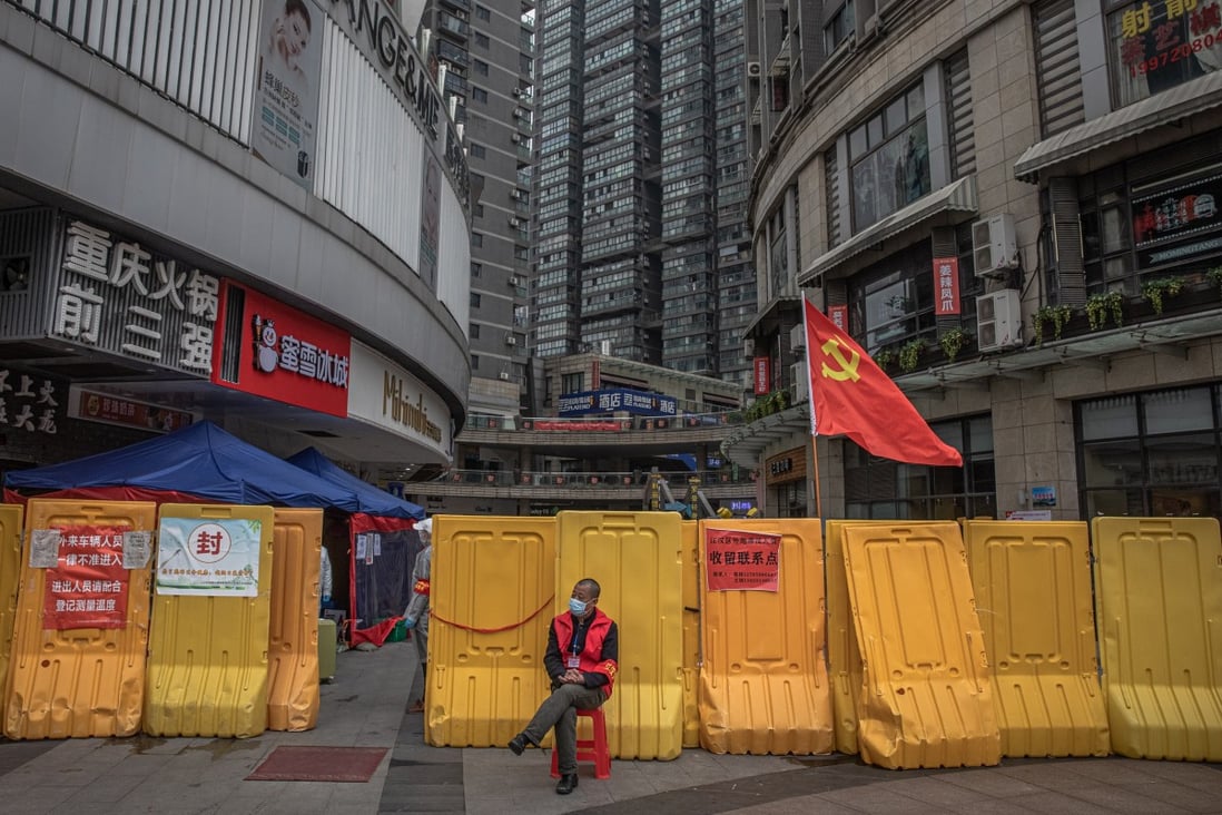 A public security volunteer guards a shopping and residential area in Wuhan on March 31. In January, Beijing imposed strict measures to put the entire province under lockdown to halt the spread of coronavirus. Photo: EPA-EFE