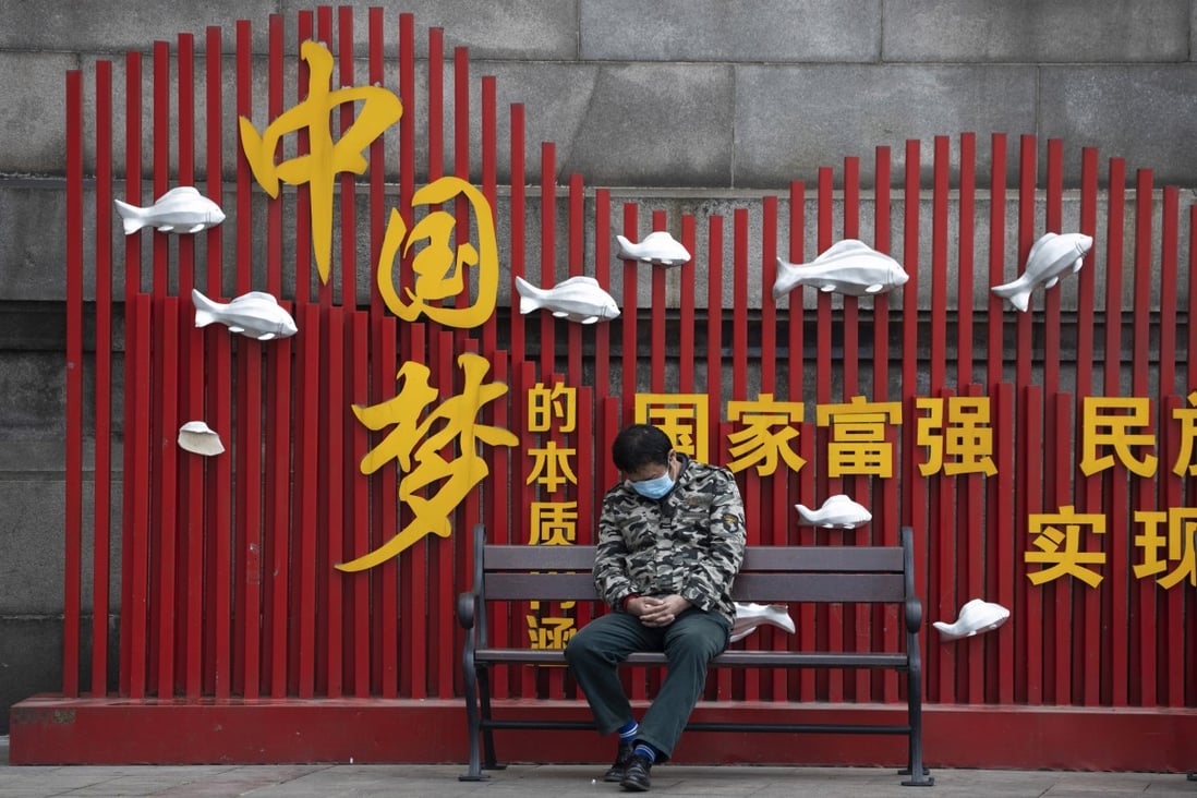 A resident naps near a sign that reads “Chinese dream” in Wuhan on Wednesday. Photo: AP