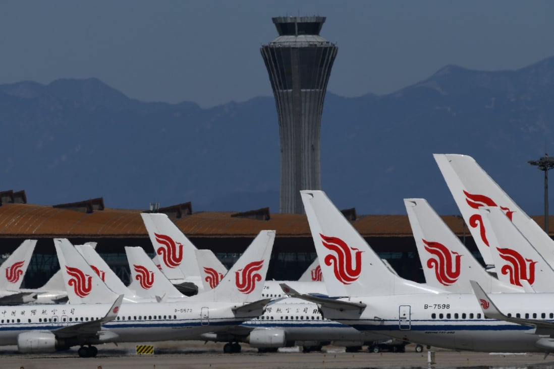 Air China planes are seen parked on the tarmac at Beijing Capital Airport. China said last week that it would drastically cut its international flight routes and bar entry to returning foreigners based in the country to stem the spread of Covid-19. Photo: AFP