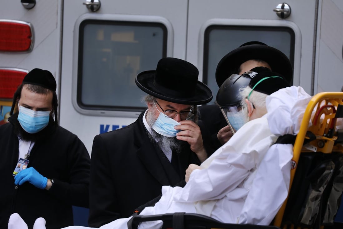 Hasidic men speak with an elderly patient being brought into Mount Sinai Hospital amid the coronavirus pandemic on April 1, 2020 in New York City. Photo: Agence France-Presse