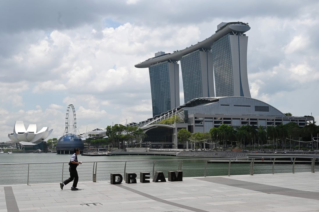A man jogs on the promenade along Marina Bay in Singapore. The island nation is slowly tightening restrictions to combat the spread of Covid-19. Photo: Agence France-Presse