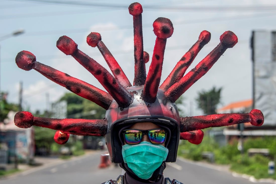 An Indonesian police officer wearing a coronavirus-themed helmet conducts a hygiene awareness campaign in Mojokerto, East Java on April 3. Photo: AFP