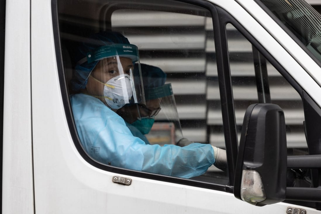 An ambulance driver in protective gear sits in his vehicle outside the Infectious Disease Centre at Princess Margaret Hospital in Hong Kong. Photo: EPA