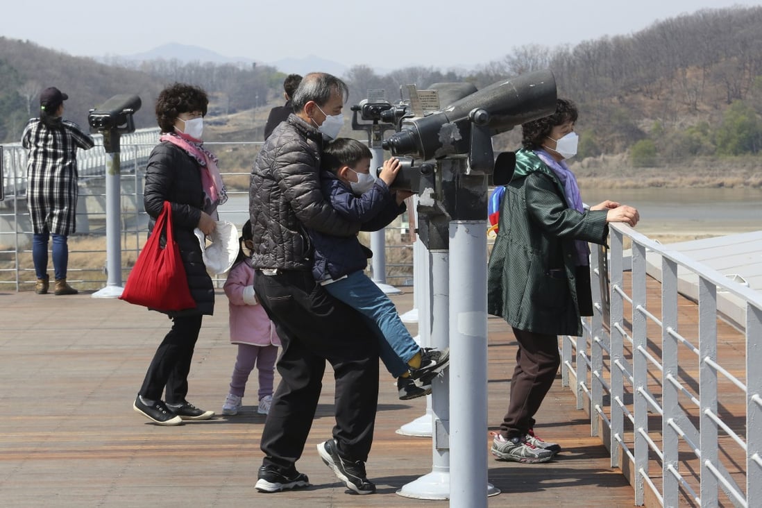 A family wearing face masks use binoculars to look across South Korea’s border with the North at Imjingak in Paju last week. Photo: AP