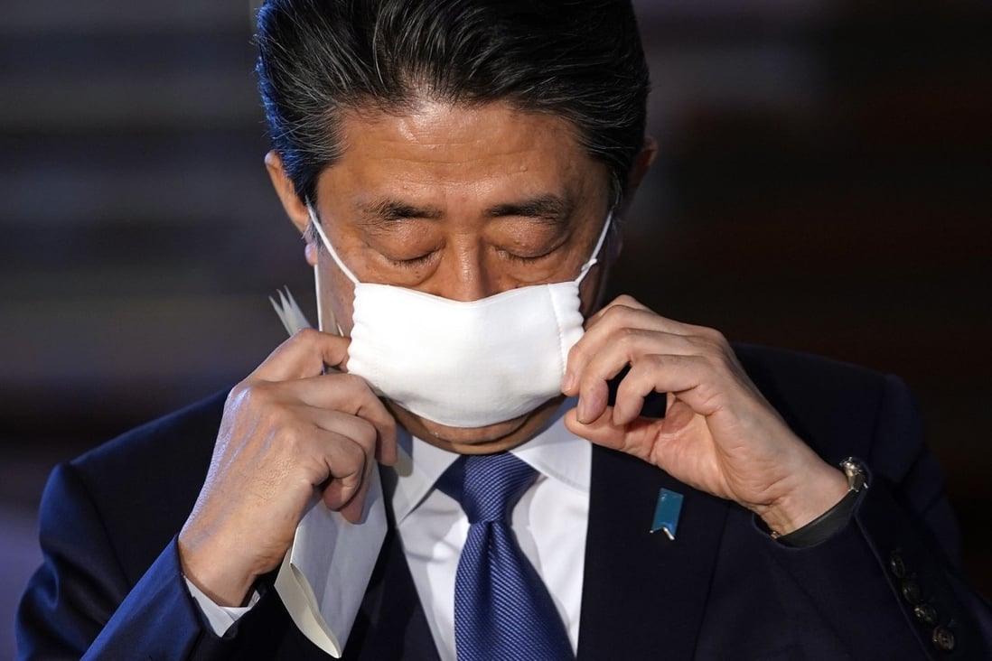 Japanese Prime Minister Shinzo Abe takes off his face mask as he arrives for a press conference at the prime minister's official residence in Tokyo on April 6, 2020. Japan is declaring a state of emergency for parts of the country and planning a huge near-US$1 trillion stimulus for households and businesses due to the virus. Photo: EPA-EFE