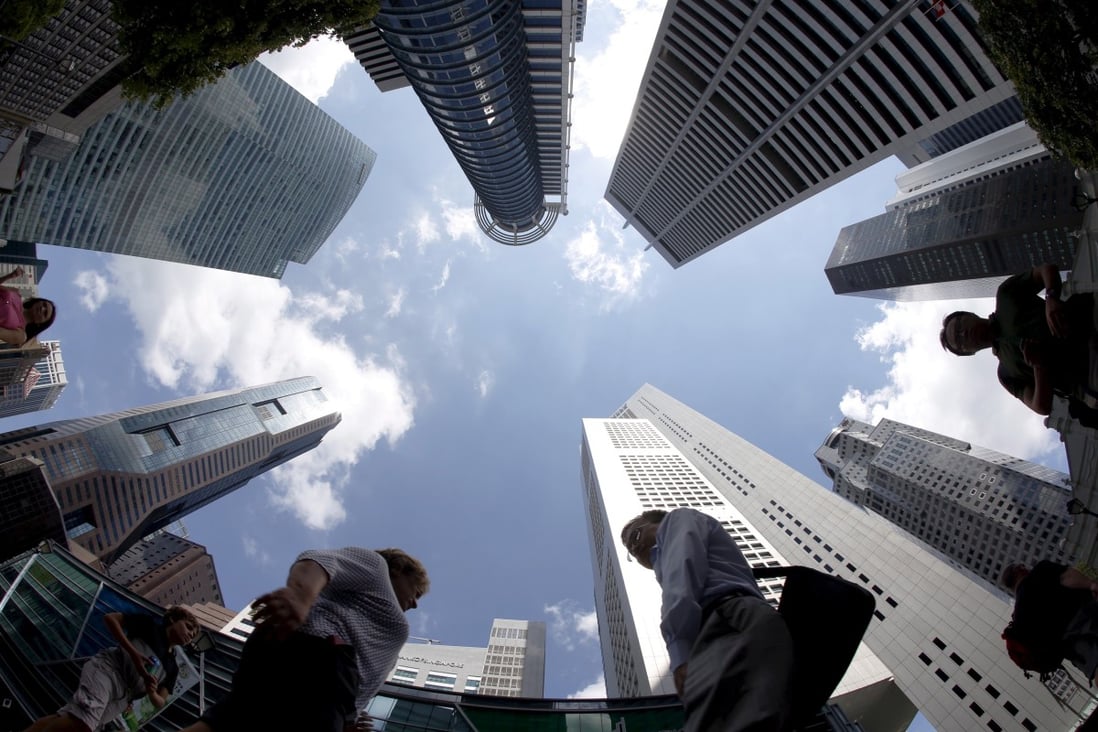 People walk past office buildings in the central business district in Singapore. Photo: Reuters