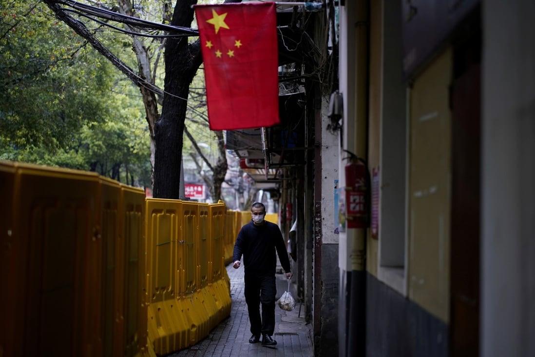 A man in a face mask walks past barriers blocking access to buildings in the central Chinese city of Wuhan, epicentre of China's coronavirus outbreak. Photo: Reuters