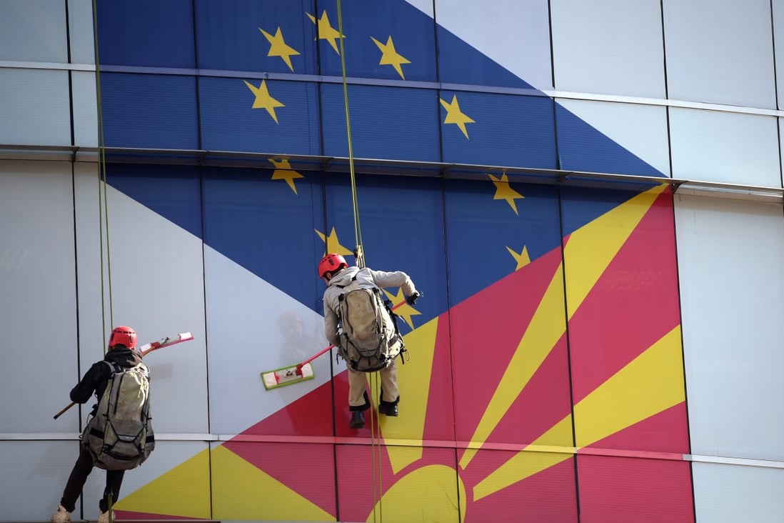 Workers clean the windows of the offices of the European Union decorated with EU and Macedonian flags in Skopje, North Macedonia, in February 2019. Photo: EPA-EFE