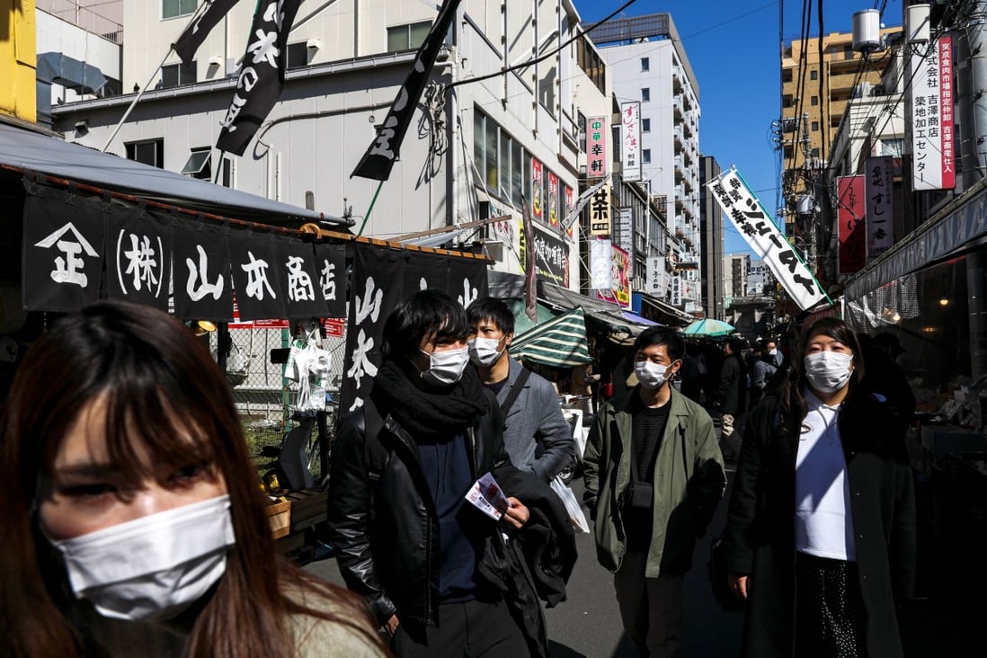 People wearing protective face mask are seen at the Tsukiji fish market in Tokyo, Japan. Shops in the area are on sale at discounts of up to 30 per cent. Photo: Reuters