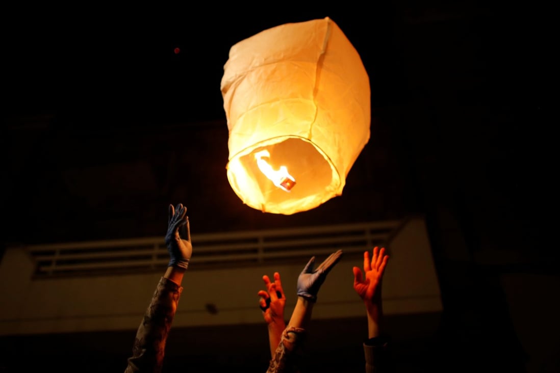 People in the small southern Italian town of San Giorgio Ionico light a paper lantern in memory of those who have died in the coronavirus pandemic. Photo: Reuters