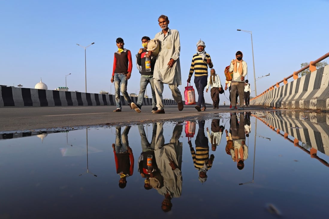 Migrant workers and their families walk along a road during the lockdown in New Delhi. Photo: Bloomberg