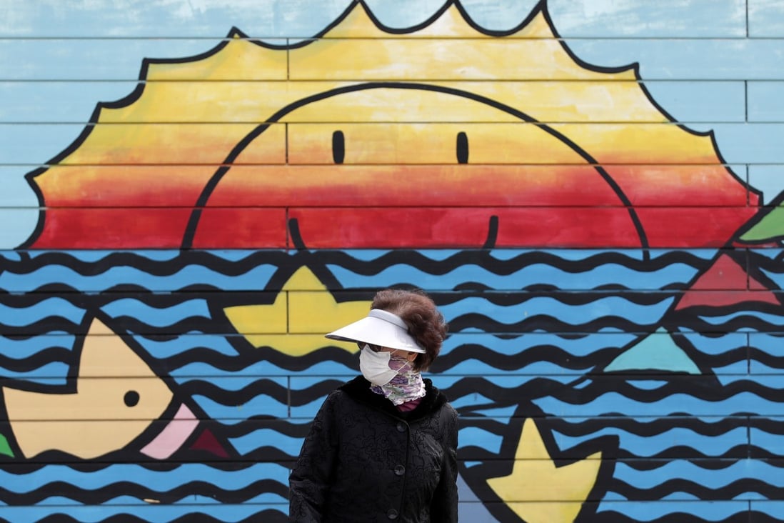 A woman wearing a face mask walks along the Han river at a park in Seoul, South Korea, on March 12. South Korea’s aggressive testing regime has helped turn the tide of the Covid-19 epidemic in the country. Photo: AP
