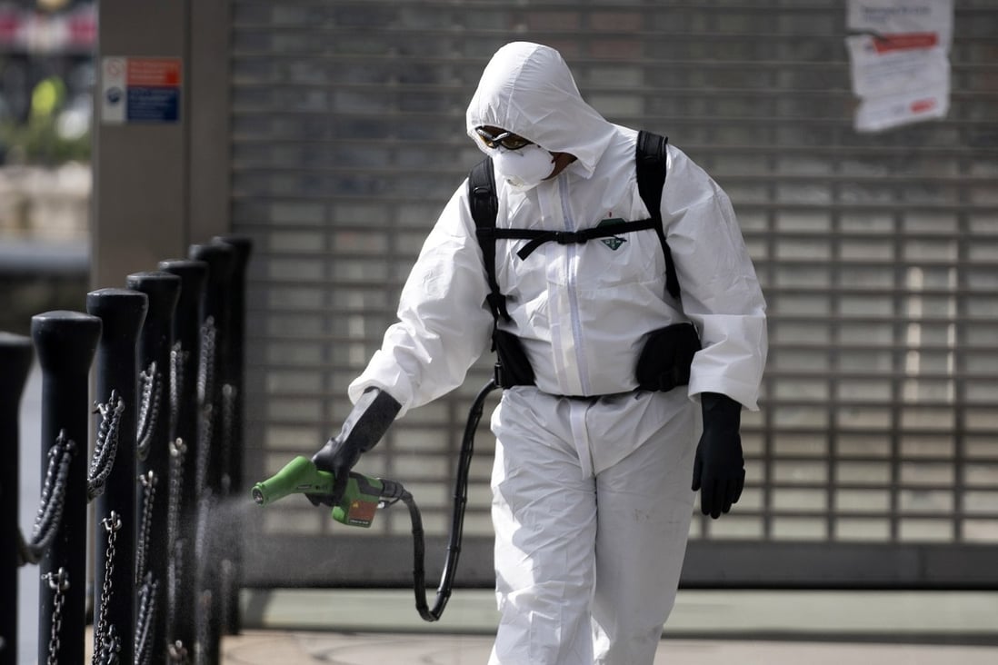 A cleaner sprays disinfectant outside an office in central London. As the coronavirus pandemic takes hold, the previously “invisible’’ cleaners, garbage collectors, sanitation officers and health care workers now occupy centre-stage. Photo: EPA-EFE