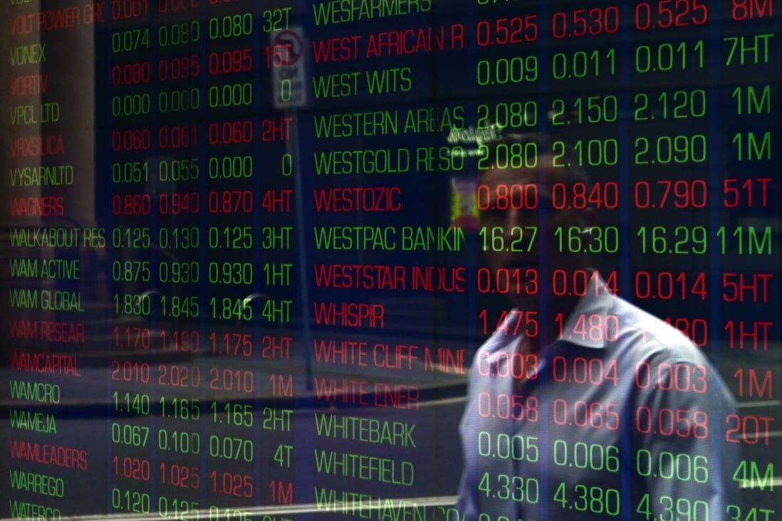 A man walks past a digital market board at the Australian Stock Exchange in Sydney. Photo: EPA-EFE
