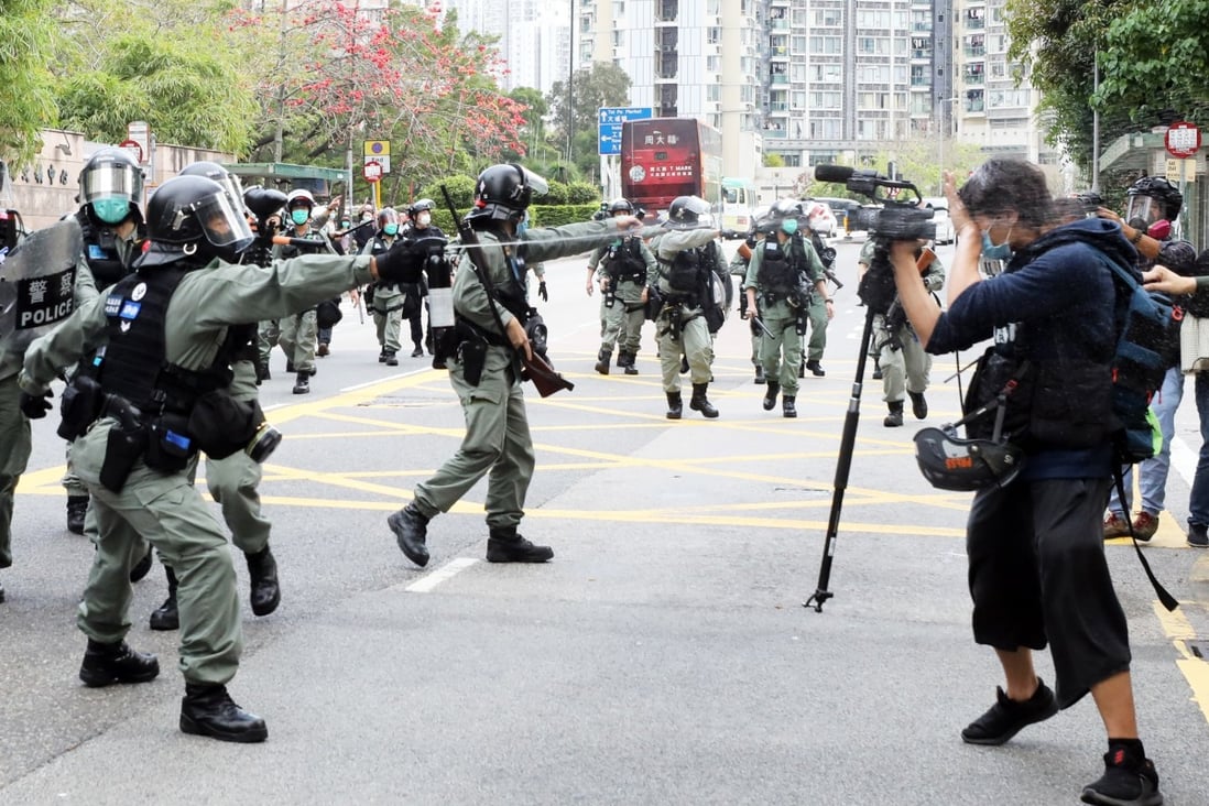 A Hong Kong police officer fires pepper spray at reporters at On Cheung Road in Tai Po on March 8. Photo: Dickson Lee