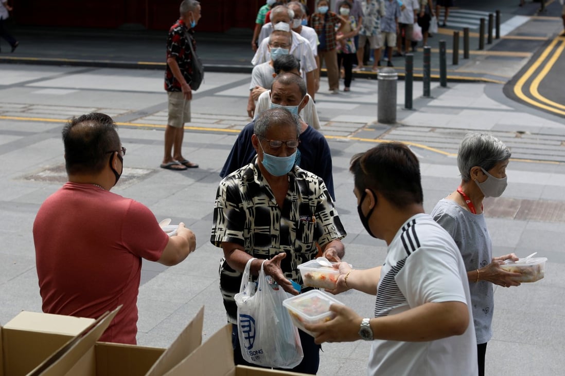 Owners of a Singapore restaurant distribute food to the elderly. Photo: Reuters