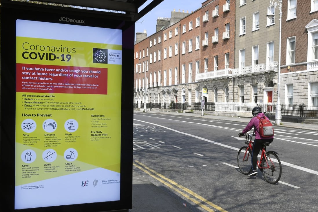 A cyclist passes by a bus stop with a public health warning on Covid-19 in Dublin on April 17, 2020. Photo: EPA-EFE