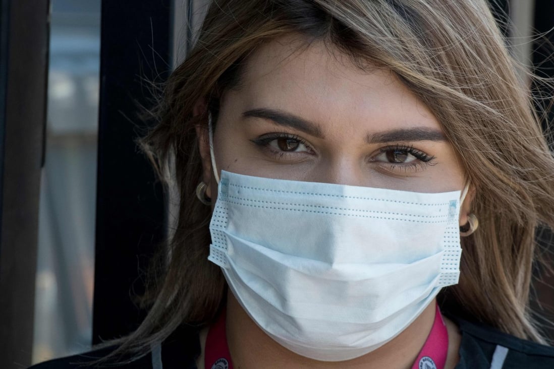 A woman wears a surgical mask amid the coronavirus pandemic. Wearing a mask can make facial blemishes and breakouts worse. Photo: AFP