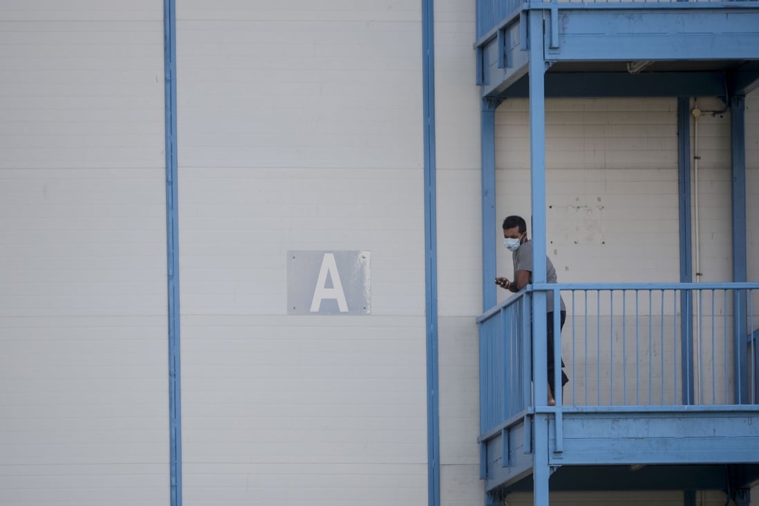 A foreign worker wearing a mask looks out from the North Coast Lodge foreign worker dormitory in Singapore on April 17. The government has been criticised for overlooking the living conditions of 1.3 million workers in essential services such as construction, transport and sanitation. Photo: EPA-EFE