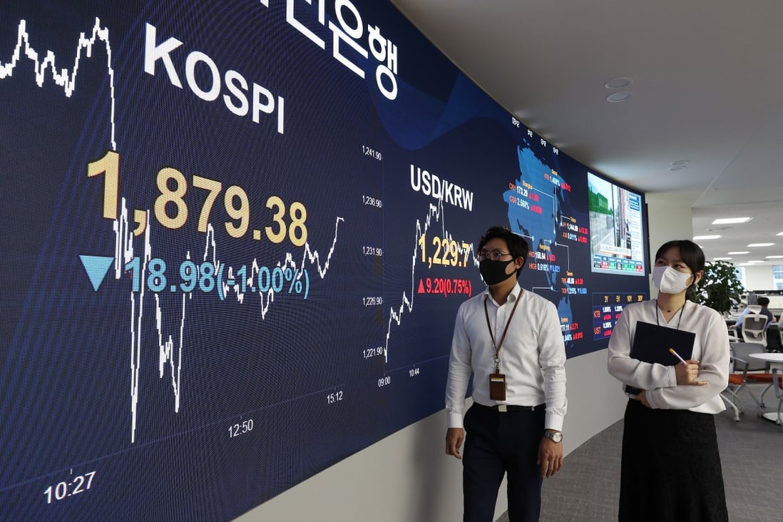 People wearing face masks look at an electronic signboard at the trading room of KB Kookmin Bank. Photo: YNA/DPA