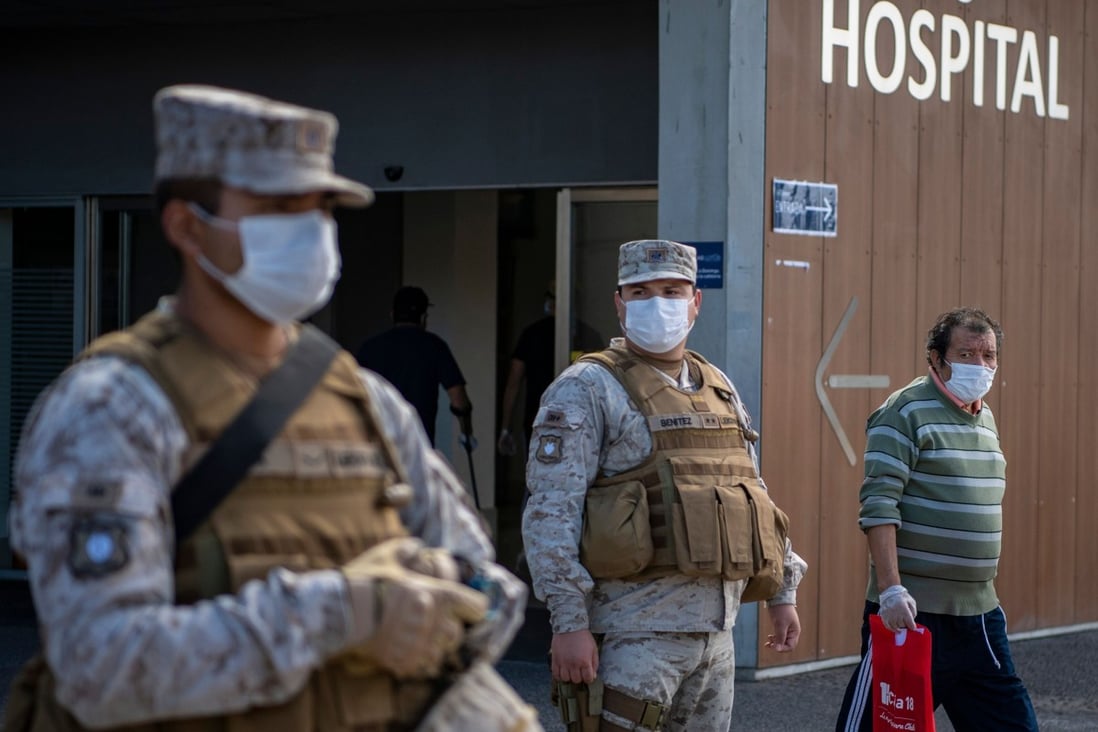 Chilean soldiers wear face masks while on guard outside Del Carmen Hospital in Santiago on Monday. Photo: AFP