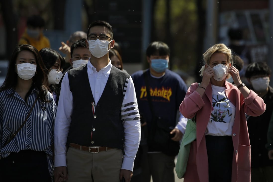 Commuters wear face masks to protect against the spread of new coronavirus as they walk through a subway station in Beijing. As the virus has travelled round the world, masks have become one of the essential commodities of 2020. Photo: AP