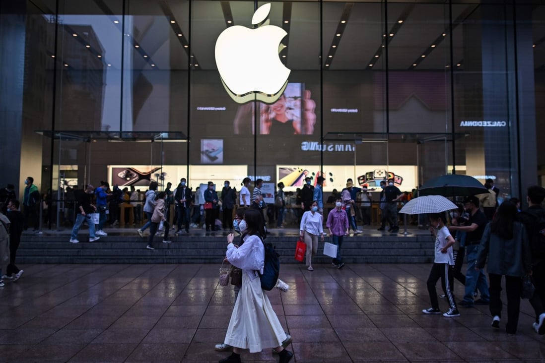 People wearing face masks walk past an Apple Store in Shanghai on May 1. With its global brand, few American companies have been exposed to the spread of the coronavirus like Apple. Photo: Agence France-Presse